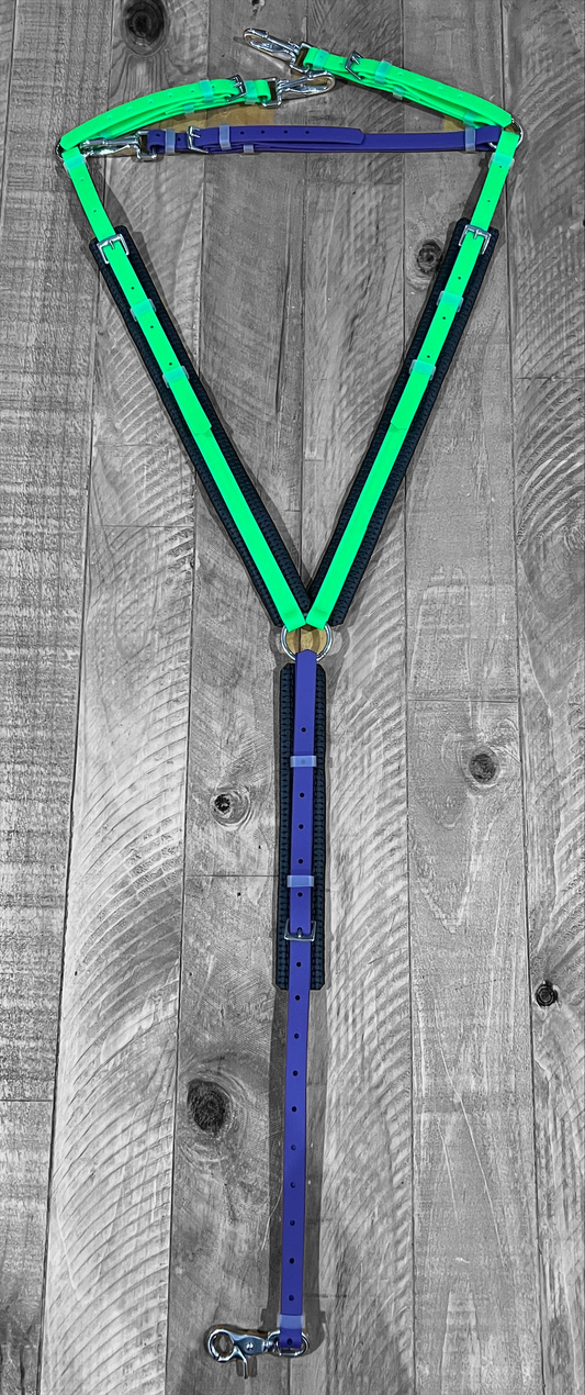A vibrant dog harness from the LS Equestrian collection is laid out on a wooden floor. This colorful piece, featuring bright green and purple BioThane breastplate straps with sturdy stainless steel fittings, forms a Y-shape design that's both durable and stylish.