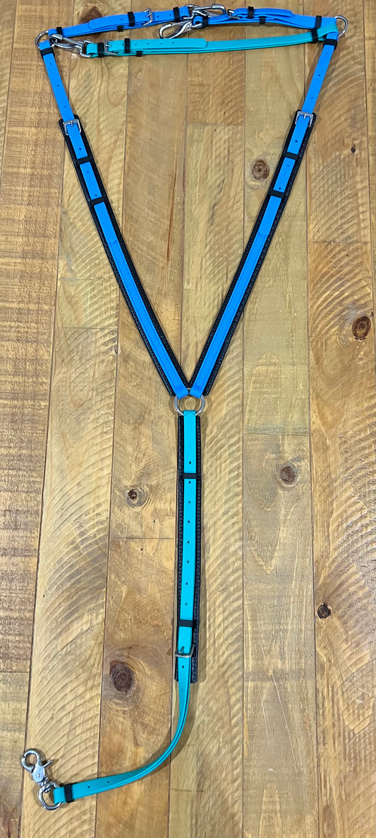 A teal and cyan harness from LS Equestrian is displayed on a wooden floor, showcasing adjustable straps with buckles and metal rings. This custom-made horse tack features a BioThane padded breastplate, providing durability and comfort for your equine companion.
